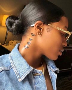 A woman with glasses and a jean jacket on.